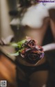 A woman in lingerie holding a bouquet of flowers.