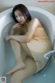 A woman sitting in a bathtub with her legs crossed.